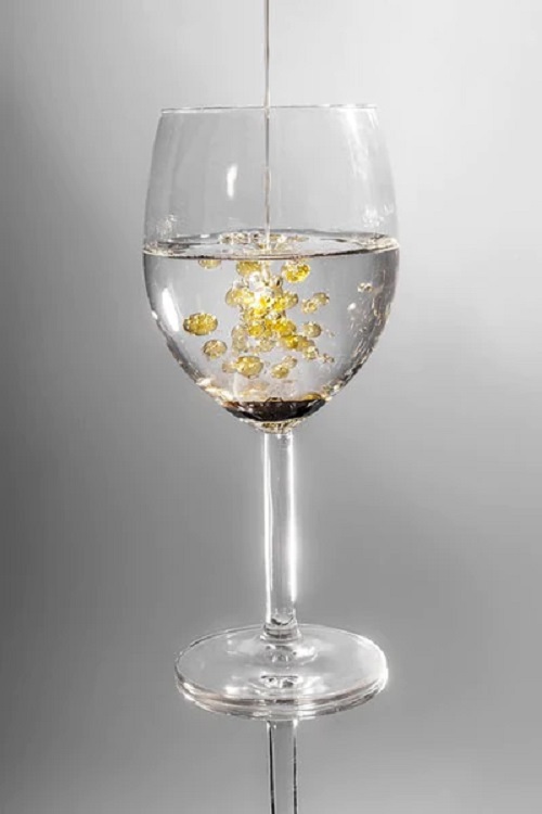 pouring castor oil in glass of water